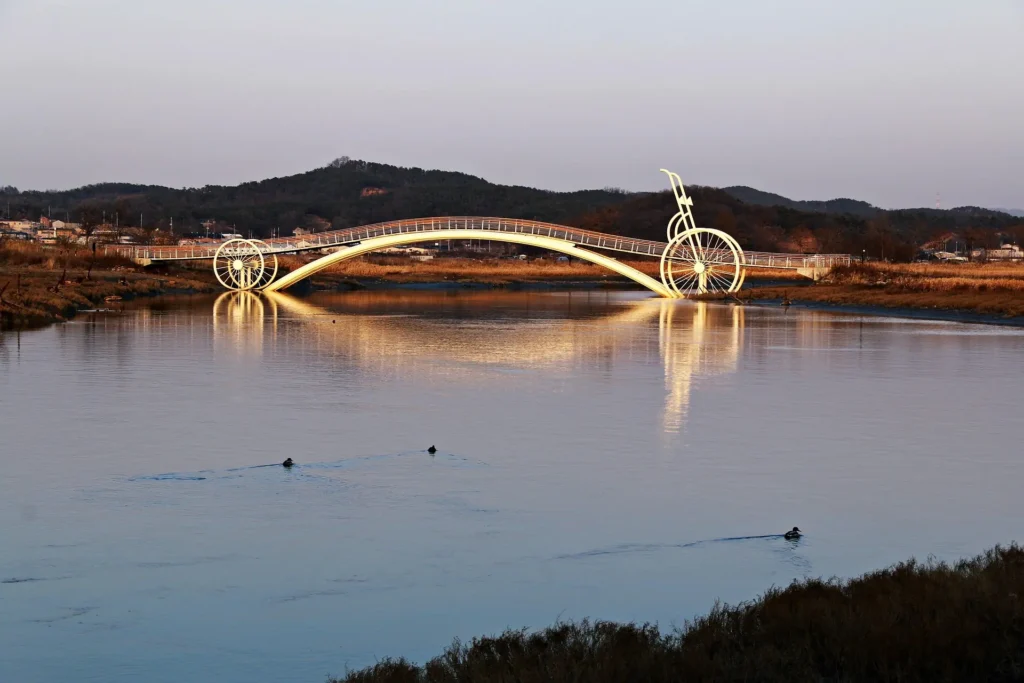 A bicycle-shaped bridge lit at dusk, symbolizing the online coaching journey from stagnation to ambition in California.